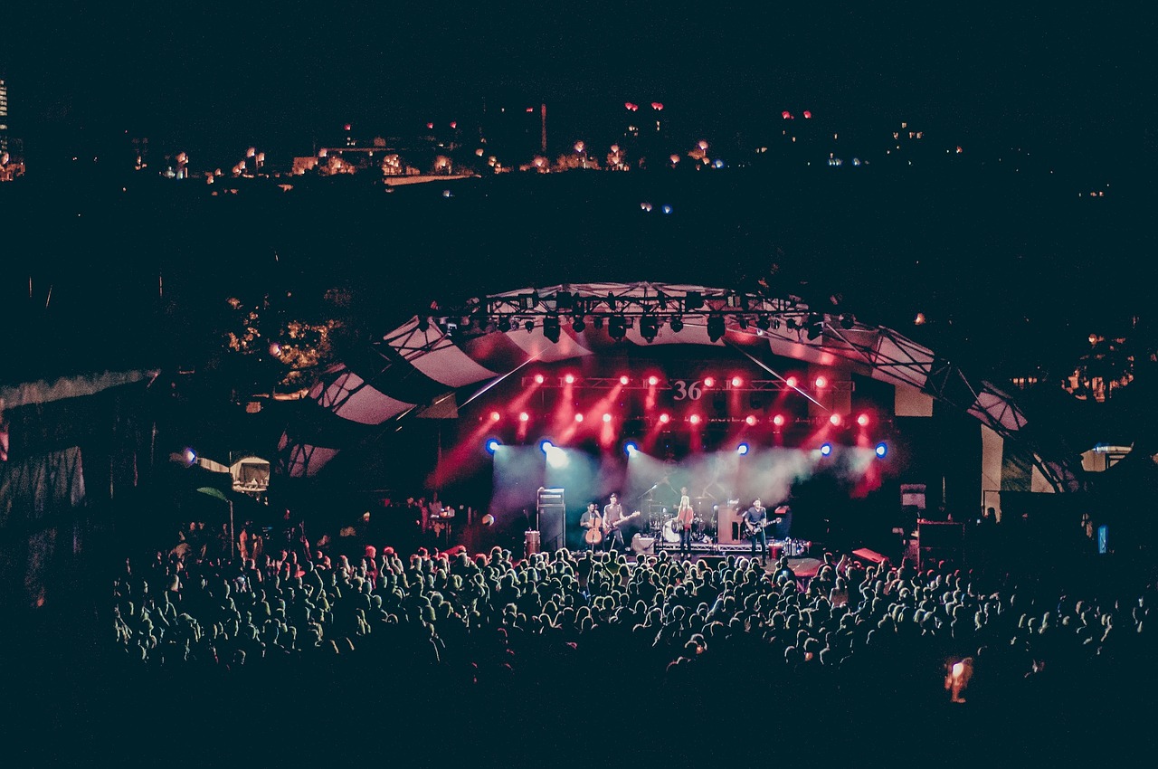 Concert crowd with hands up and colorful stage lights